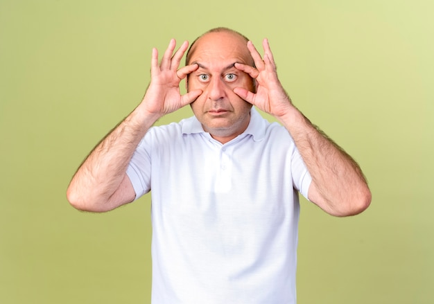 mature-man-opening-eyes-with-fingers-isolated-on-olive-green-wall_141793-74897.jpg