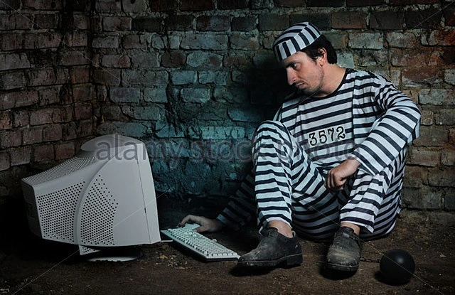 prisoner-in-a-dark-cell-working-with-computer-bb5jd6-1492165883297.webp